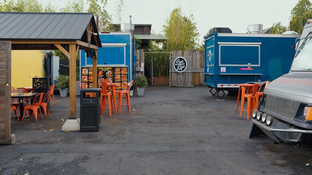 Blue food carts and seating at the Alberta Carts pod on NE Alberta