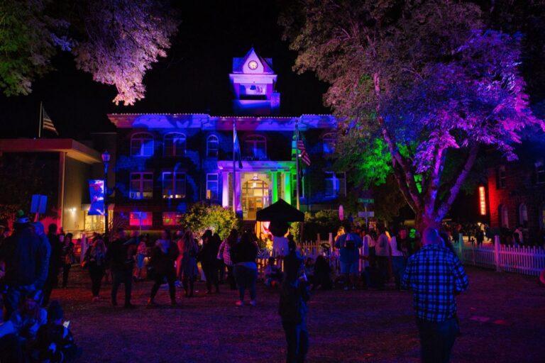 Downtown St. Helens at night during Spirit of Halloweentown, with the town square lit in purple and green