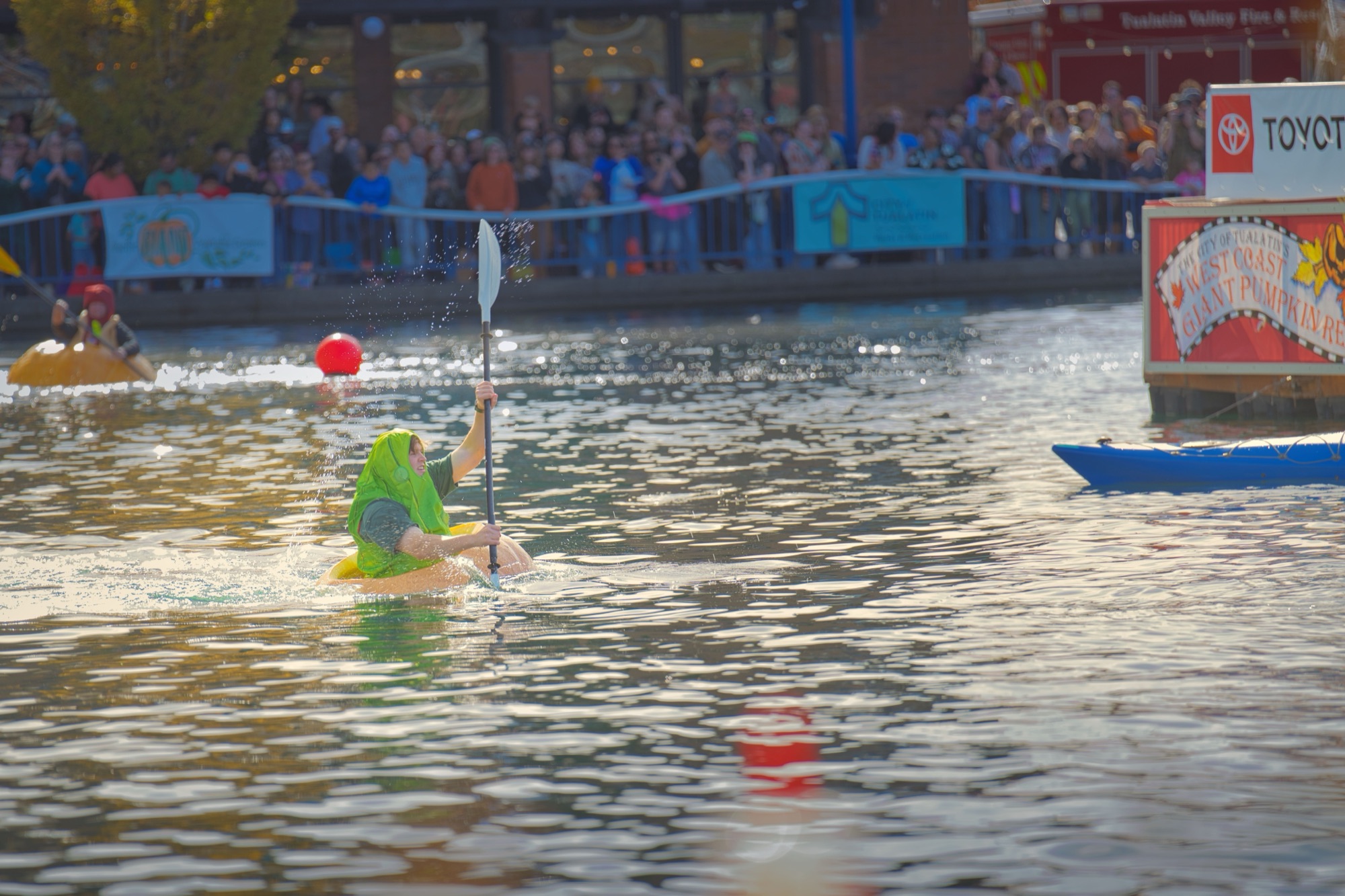 A paddler in a pickle suit in a giant pumpkin, winner of the fifth race