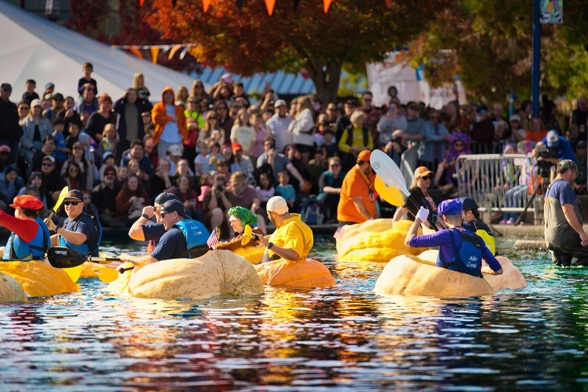 Spectators lined up along the Tualatin Commons lake wall as pumpkin racers wait at the starting line